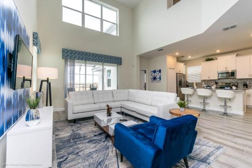 a living room with a white couch and blue chairs at Beautiful Home wPrivate Pool & Spa, near WDW in Kissimmee
