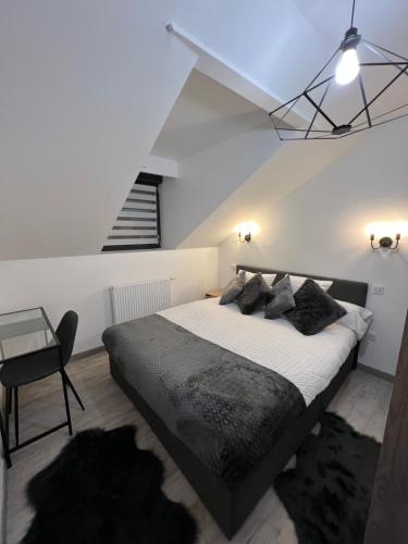 ein Schlafzimmer mit einem großen Bett und einer Treppe in der Unterkunft Appartement haut de gamme avec Jacuzzi Champagnole in Champagnole