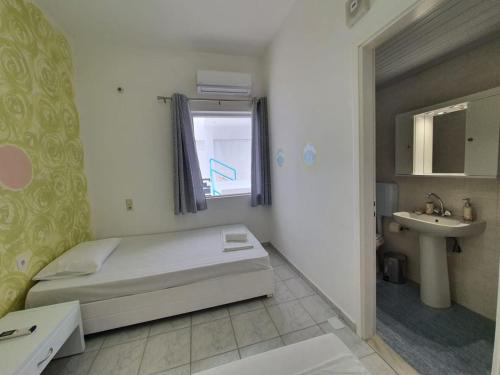 Dormitorio pequeño con cama y lavamanos en Cozy Beach House South Crete en Paránimfoi