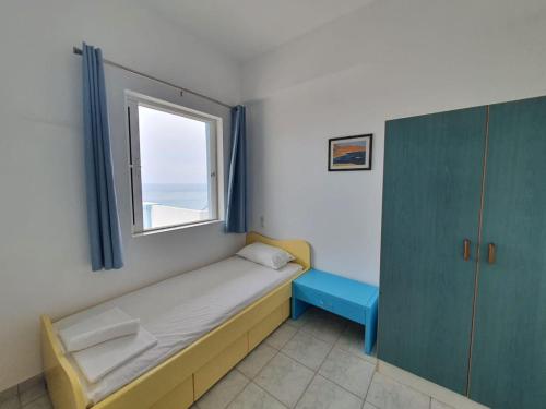 um pequeno quarto com uma cama e uma janela em Cozy Beach House South Crete em Paránimfoi