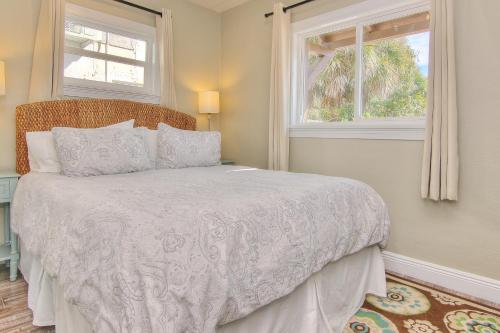 a bedroom with a bed and two windows at Bungalow Beach Place 4 in Clearwater Beach