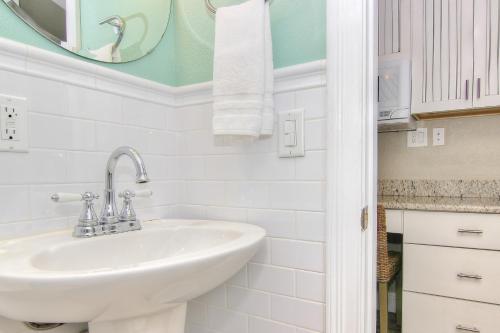 La salle de bains blanche est pourvue d'un lavabo et d'un miroir. dans l'établissement Bungalow Beach Place 4, à Clearwater Beach