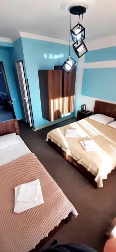 two beds in a room with blue walls at TAMAZI in Kobuleti