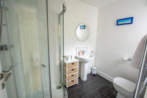a bathroom with a shower and a sink and a toilet at Helena Cottage in Elie