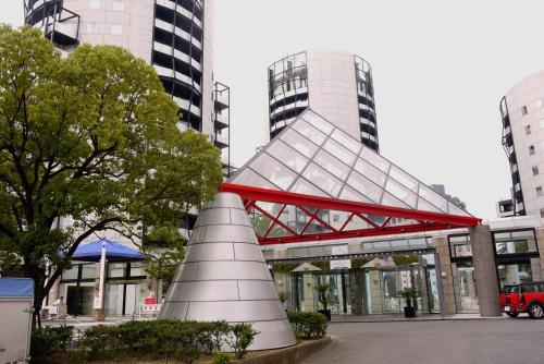 a building with a red bridge in a city at The Residential Suites Fukuoka in Fukuoka