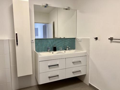 a white bathroom with a sink and a mirror at Bobr in Rozvadov