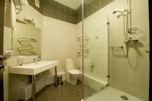 
a bathroom with a sink, toilet and shower at Arena Hotel in Minsk
