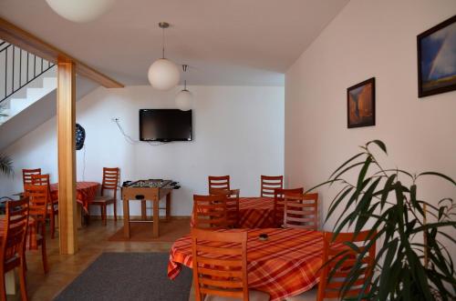 a dining room with a table and chairs and a tv at Penzion Naděje in Benešov nad Černou