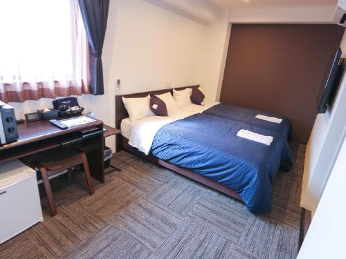 a hotel room with a bed and a desk at HOTEL LiVEMAX Chiba-Ekimae in Chiba