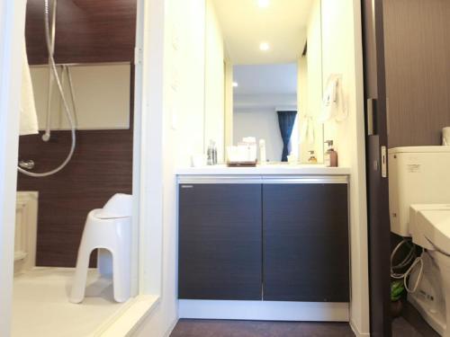 een badkamer met een douche, een wastafel en een toilet bij HOTEL LiVEMAX Chiba-Ekimae in Chiba