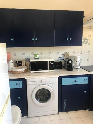 a kitchen with a washing machine and a microwave at Casa dos Pais in Odeceixe
