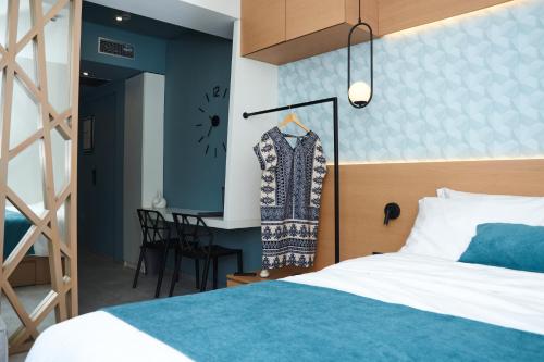 a bedroom with a bed and a dress hanging on a rack at 7Rizes Luxury Living in Heraklio Town