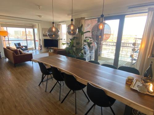 a living room with a large wooden table and chairs at Scheveningen Diamond View Beach and Harbour in Scheveningen