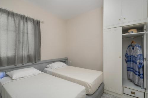 two beds in a room with a window at Vira Vivere Houses in Plaka Milou