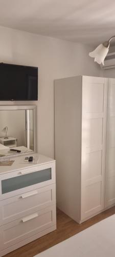 a kitchen with white cabinets and a flat screen tv at Villa Mila in Bol