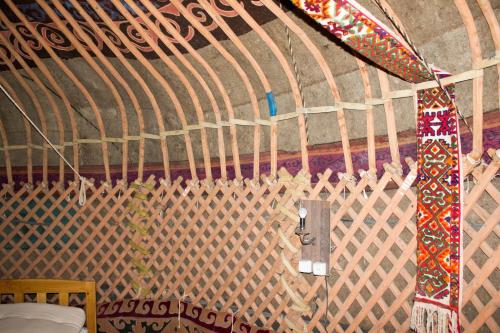a tie hanging from a wall with a curtain at Kyzylkum Nights Camp & Family Yurt in Nurota
