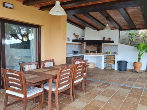 a kitchen and dining room with a wooden table and chairs at VILLA LA CALA with swimming pool & sea view, 10 min walk from the sea in Blanes