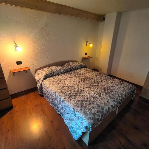 1 dormitorio con 1 cama y 2 luces en 2 mesas en La Maison Lillà, en Fenis