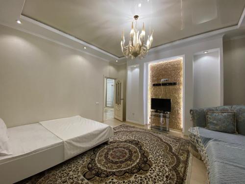 1 dormitorio con cama, sofá y lámpara de araña en Однокомнатная элитная квартира в районе Экспо, en Astana