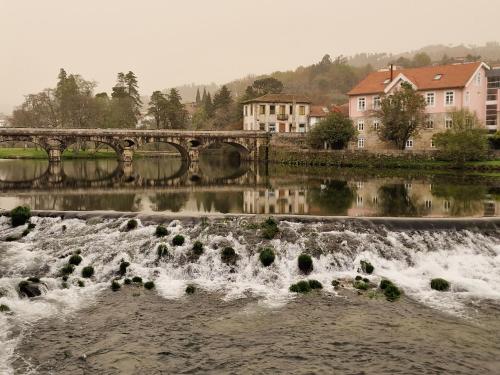 a bridge over a river with a waterfall at Daisy's place in Arcos de Valdevez