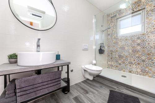 een badkamer met een wastafel, een toilet en een spiegel bij La Terza in Krk