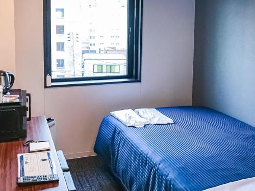 名古屋市にあるホテルリブマックス名古屋桜通口の小さなベッドルーム(ベッド1台、窓付)