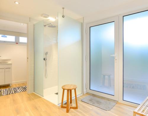 a room with a glass shower and a stool at Sea Mist in Polzeath