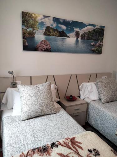 sypialnia z dwoma łóżkami i obrazem na ścianie w obiekcie apartment garden w mieście Caldas de Reis