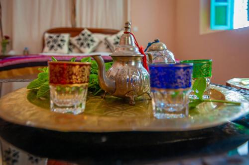 una mesa con cuatro vasos y una tetera en ella en Riad Dar Mamouni, en Marrakech
