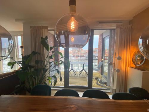a dining room with a table and chairs and a large window at Scheveningen Diamond View Beach and Harbour in Scheveningen