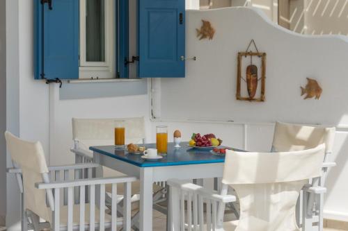 a blue table and chairs in a kitchen with blue cabinets at Vira Vivere Houses in Plaka Milou