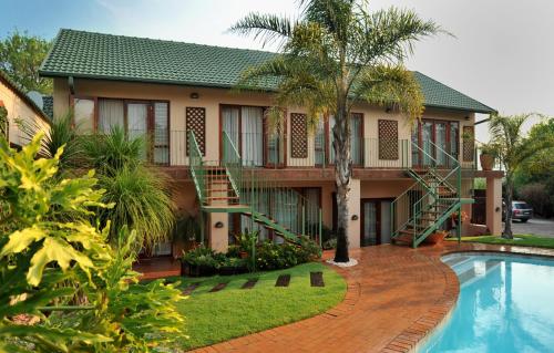 uma casa com uma piscina em frente em Claires of Sandton Luxury Guest House em Joanesburgo