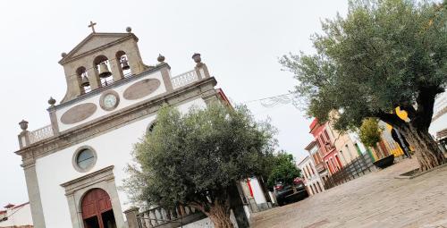 a church with a clock tower on a street at Casa Rural Encarna in Vega de San Mateo