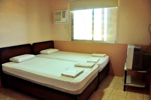 a bedroom with a bed with towels on it at GV Hotel - Ipil in Ipil