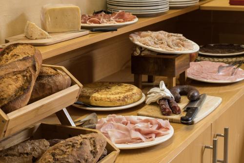 una vitrina con diferentes tipos de pan y carnes en Hotel Alta Garrotxa, en Tortellà