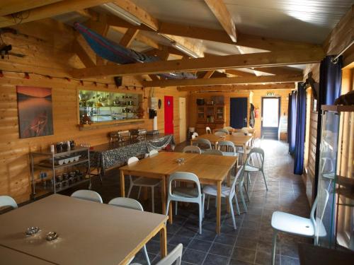 ein Restaurant mit Holzwänden, Tischen und Stühlen in der Unterkunft Holiday home OSSA Basecamp in Sint Odiliënberg