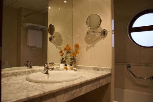 La salle de bains est pourvue d'un lavabo, d'un miroir et d'une douche. dans l'établissement Coto Real, à Rábade