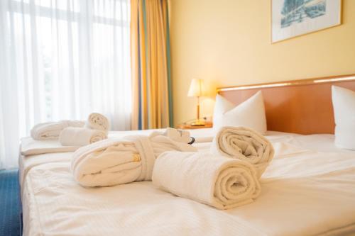 a hotel room with towels on a bed at Arkona Strandhotel in Binz