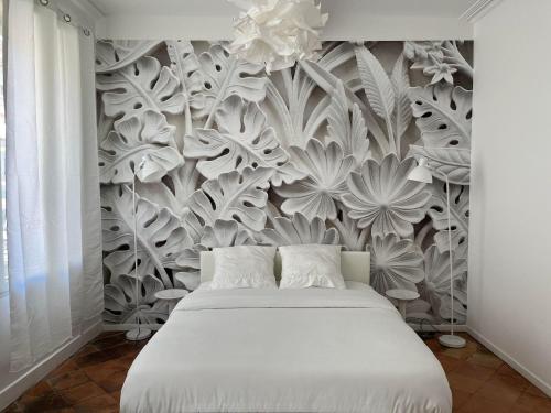1 dormitorio con 1 cama y un mural floral en la pared en Convivial PAUL SIBRA-T2-BILLARD- wifi-Vélo en Castelnaudary