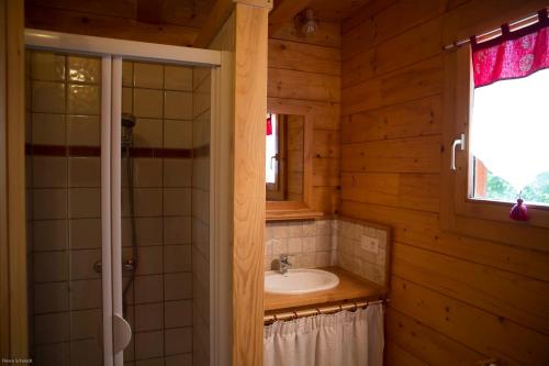 un bagno con lavandino, specchio e finestra di La Planque des Marmottes a Servoz