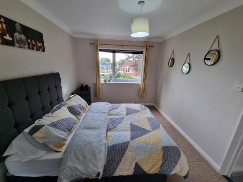 Schlafzimmer mit einem Bett und einem Fenster in der Unterkunft Swan Path Retreat - 2 Bedroom Apartment in Heybridge