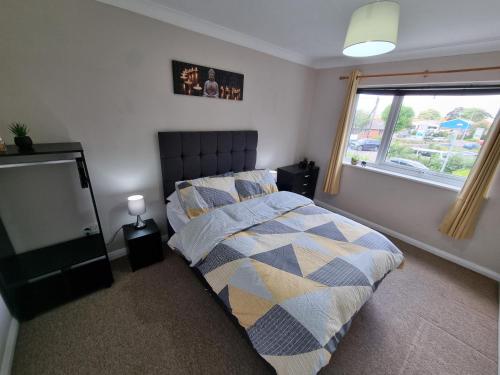 a bedroom with a bed and a window at Swan Path Retreat - 2 Bedroom Apartment in Heybridge