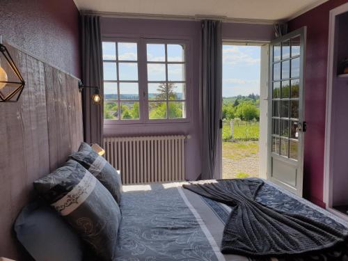 Un dormitorio con una cama y una ventana grande. en Auberge du Bois de l'étang - Motel les Tilleuls, en Peyrat-le-Château