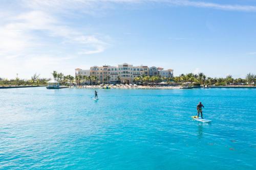 two people on surfboards in a large body of water at Blue Haven Resort- All Inclusive in Grace Bay