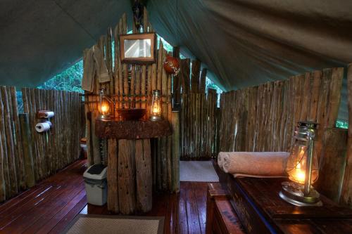 a room with a couch and a table in a tent at Quatermain's 1920's Safari Camp – Amakhala Game Reserve in Amakhala Game Reserve