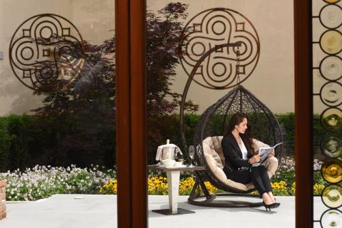 a woman sitting in a chair reading a book at Santa Croce Boutique Hotel in Venice