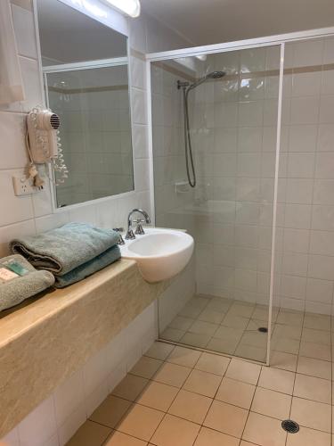 uma casa de banho com um lavatório e um chuveiro em LaTrobe Motel em Morwell