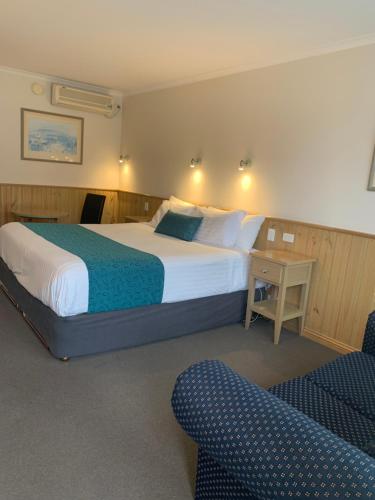 um quarto de hotel com uma cama, uma mesa e uma cadeira em LaTrobe Motel em Morwell