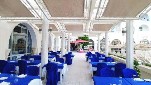 a room with blue and white tables and chairs at El Mehdi Beach Resort ex Primasol El Mehdi in Mahdia