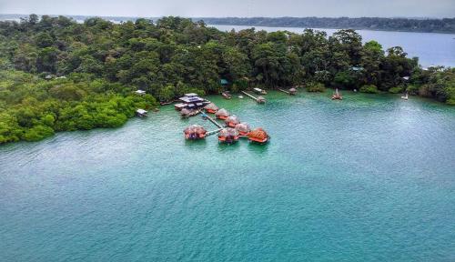 an aerial view of an island with umbrellas in the water at Eclypse de Mar Acqua Lodge in Bastimentos